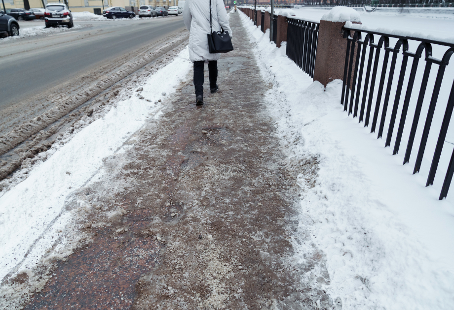 person walking on a snowy, slushy sidewalk